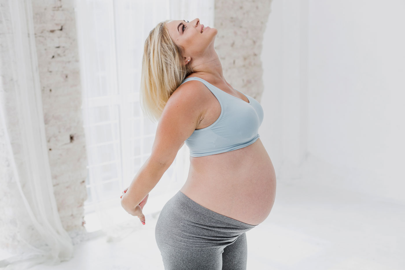 medium-shot-happy-pregnant-woman-exercising-1400